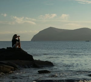 Galapagos Legend Itinerary West Expedition: A Traveler using binoculars at Egas Port